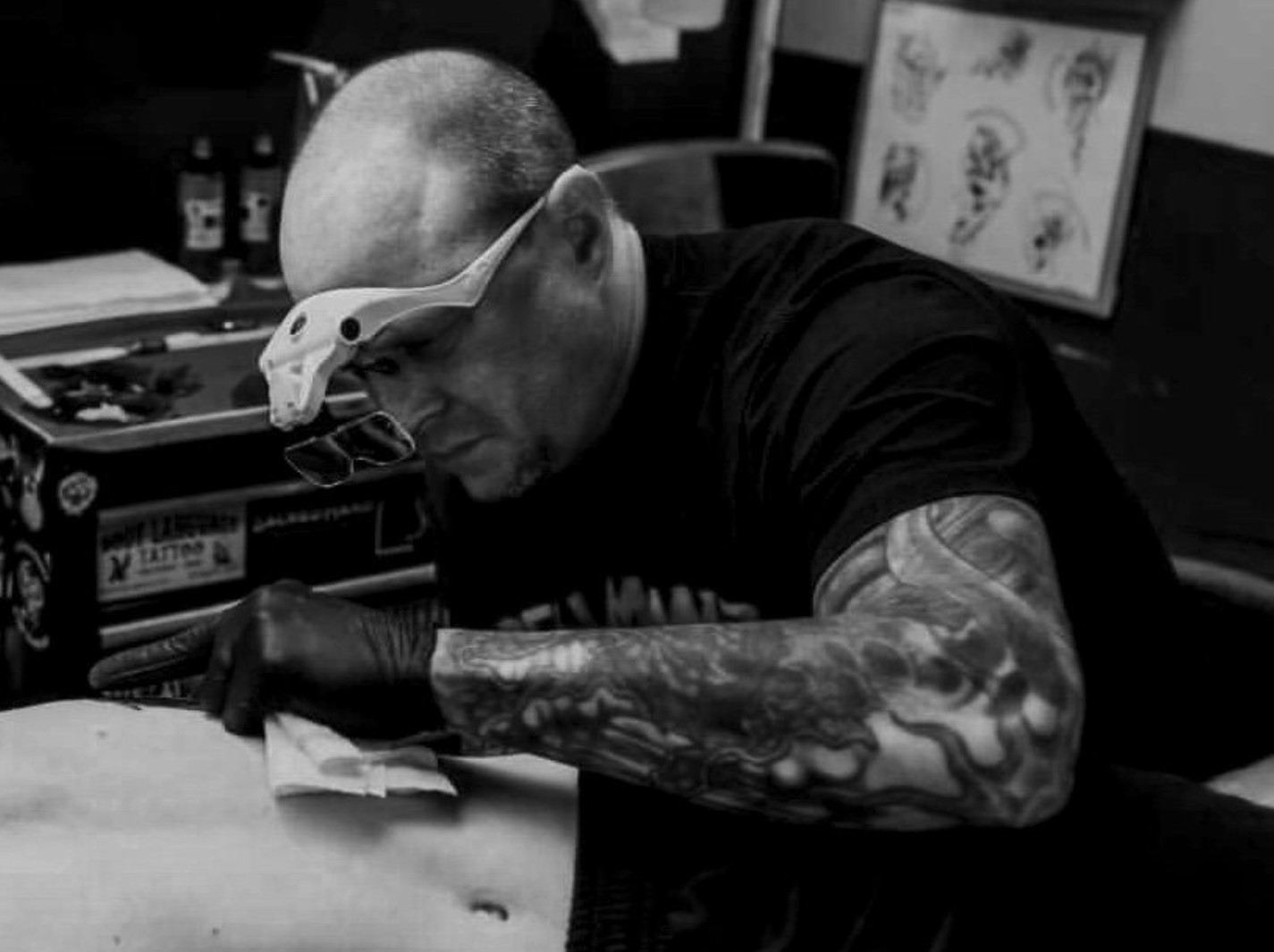 Tattoo artist Dan Wes working on a floral tattoo