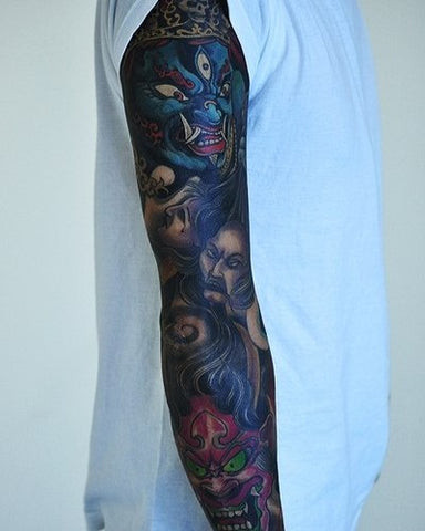 Demon sleeve tattoo featuring fierce demons and gothic elements in dark colors