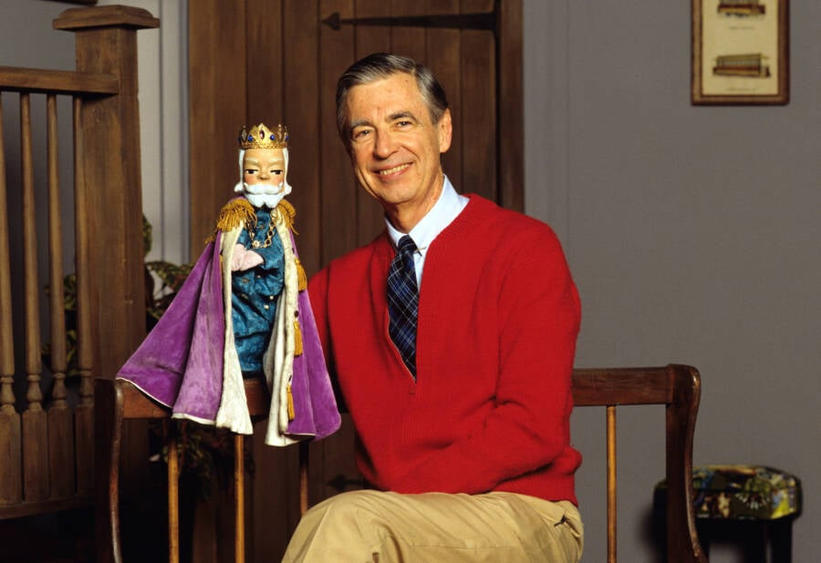 Mr. Rogers in his signature cardigan, addressing the camera with a warm smile.