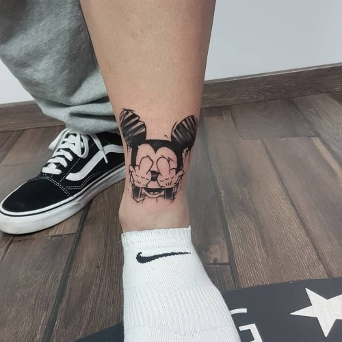 Minimalist Mickey Mouse tattoo on a man's wrist