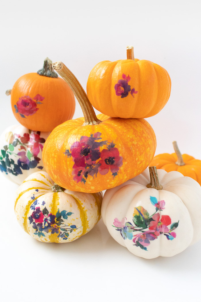 Group of decorated mini pumpkins with various temporary tattoo designs, showcasing different fall decor styles.