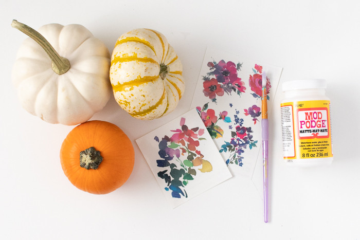 Finished temporary tattoo pumpkins arranged on a bookshelf as part of fall home decor.