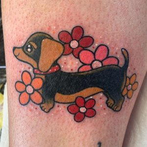 A small and charming cute dog tattoo with simple lines and a sweet expression.