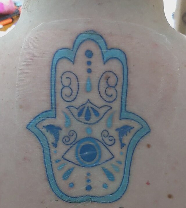 Dolphin hamsa under Tegaderm.