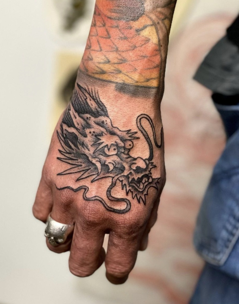 Dragon tattoo design covering the hand