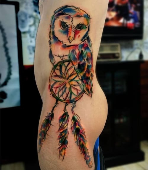 Two dreamcatcher tattoos on men, one on the chest with a stylized dreamcatcher mandala and another on the shoulder with a geometric dreamcatcher pattern.