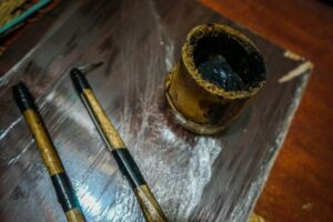 Traditional Iban tattoo tools, including bamboo sticks, a metal spike, and natural ink.