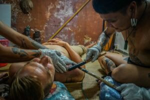 The author experiencing the hand-tapped tattoo process, a mix of pain and cultural immersion.