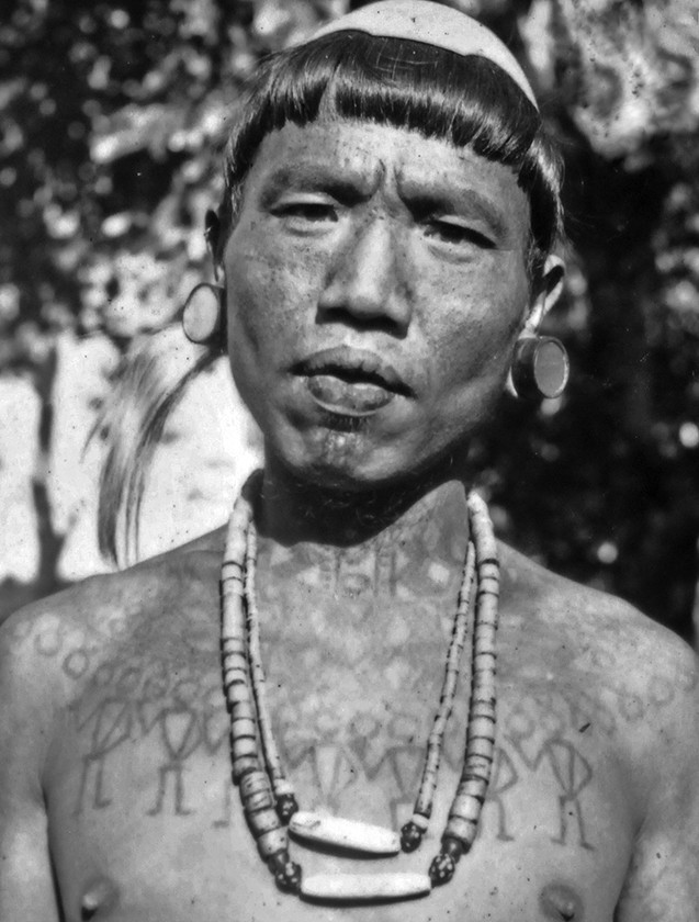 Wancho headhunters with neck and figure tattoos, displaying battlefield victories