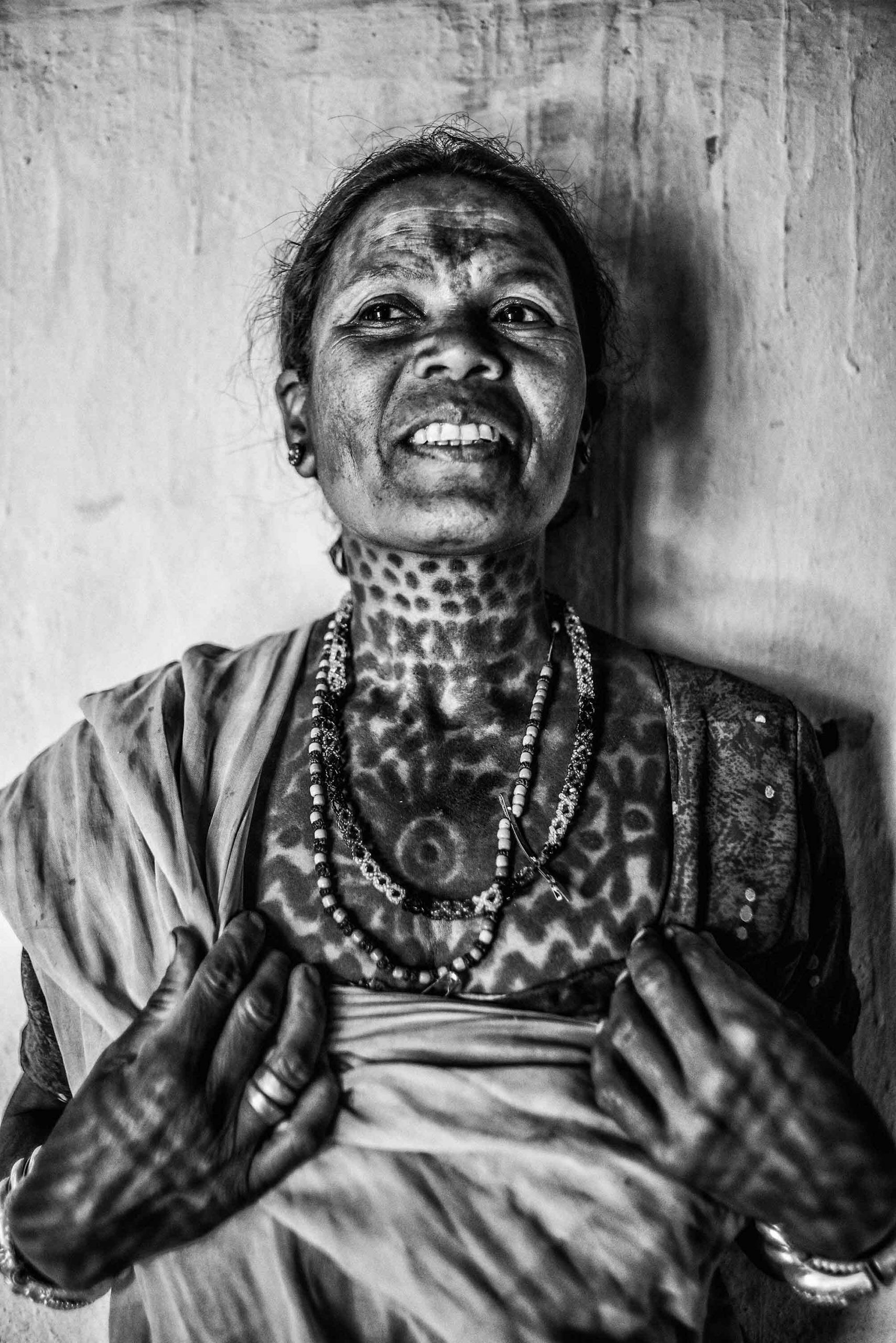 Tihro Bai's neck and chest tattoos, sun and water motifs