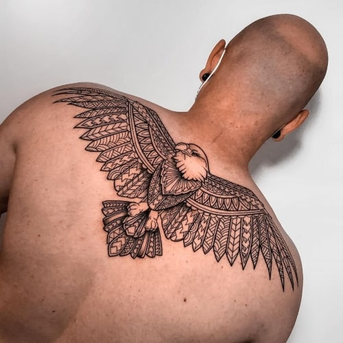 Two eagle tattoos on men, one on the chest with a traditional American eagle with flag and another on the forearm with a realistic bald eagle head.