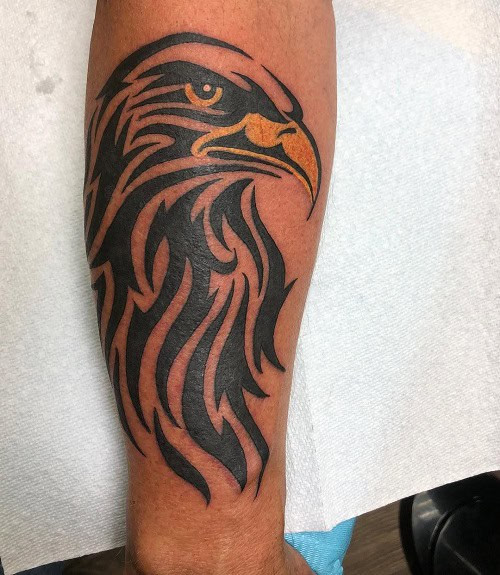 Tribal eagle tattoo on a man's chest, featuring an eagle with outstretched wings and tribal patterns.