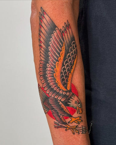 Majestic eagle forearm tattoo in black and gray with wings spread wide, symbolizing freedom, strength, and soaring ambition.