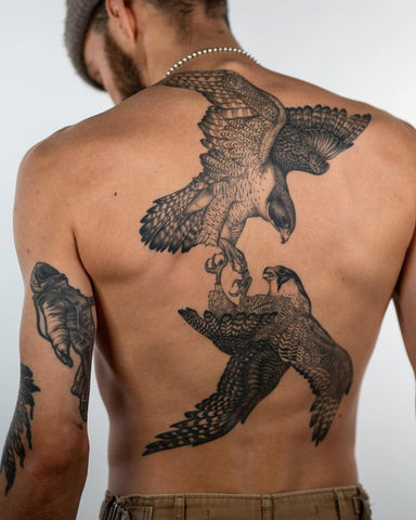 Majestic eagle back tattoo for men, wings spread wide in flight across the upper back in detailed black and gray.