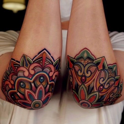 An elbow mandala tattoo with circular design on a man's elbow, distinctive