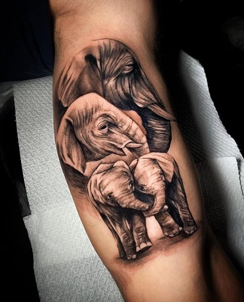 Detailed elephant family silhouette tattoo on a man's forearm, representing family loyalty and wisdom.