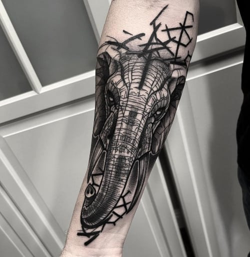 Geometric elephant tattoo on the chest, combining nature and modern art in men tattoo ideas.