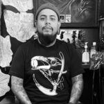 Renowned tattoo artist Emmanuel Mendoza, creator of the Death Wish Coffee tattoo design, pictured in his Ohio studio. Explore his unique coffee tattoo art.