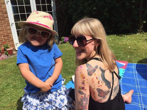 Alice and five-year-old Ruby engaging in a playful tattoo session with stickers