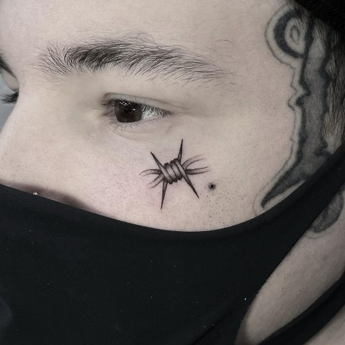 Face tattoo with a minimalist design, a bold and modern placement for men.