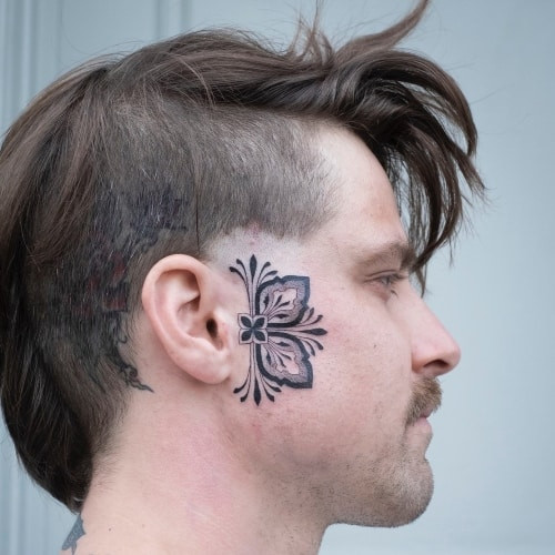 Face tattoo with ornamental design around the eye on a woman's face