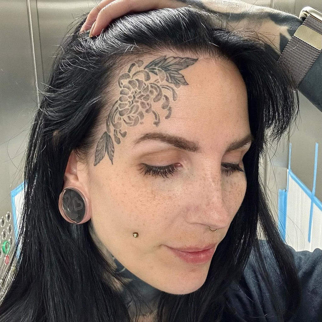 Elaborate blackwork face tattoo with intricate patterns and shading, a bold and cool example of detailed facial ink.