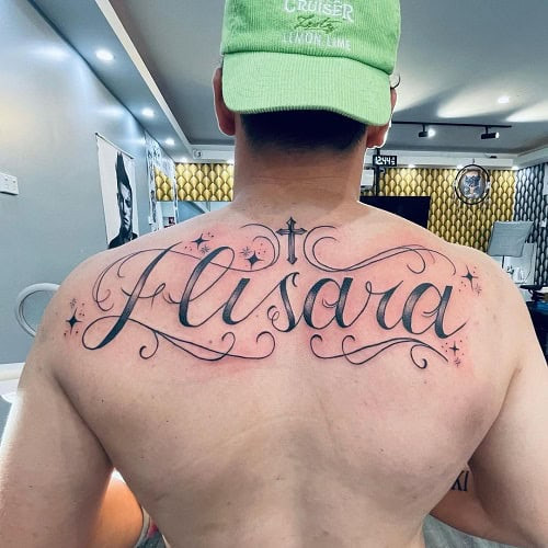 Stylish family name tattoo in script font on a man's forearm, a proud display of family heritage.