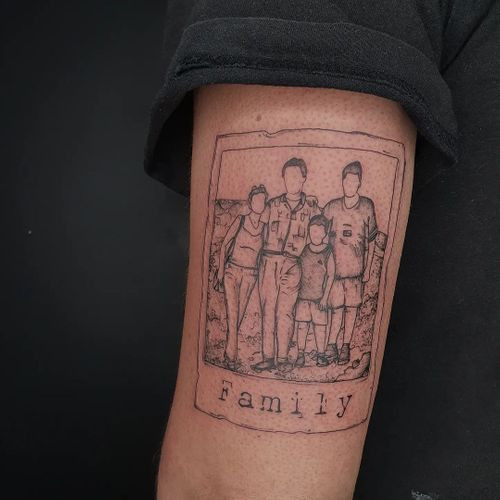 Handwritten name tattoo in cursive script on a man's forearm