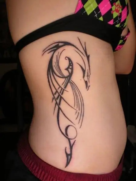 Dragon line art tattoo on the side rib cage showcasing strength in simplicity