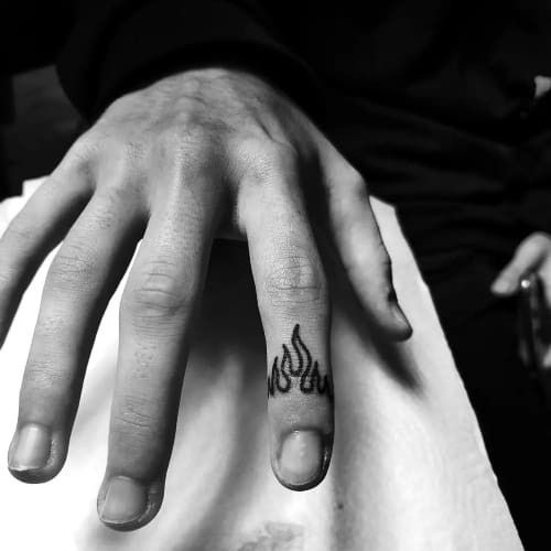 Finger tattoos with symbols and letters on a man's hand