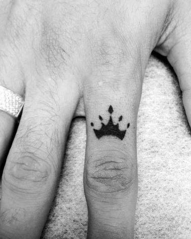 Finger tattoo of stylized crown with geometric elements, modern regal design