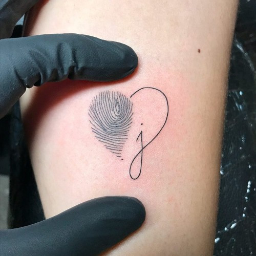 Fingerprint heart tattoo on the finger, a unique and personal men tattoo idea.