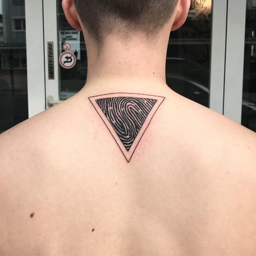 Two fingerprint tattoos on men, one on the chest with a stylized fingerprint mandala and another on the shoulder with a geometric fingerprint pattern.