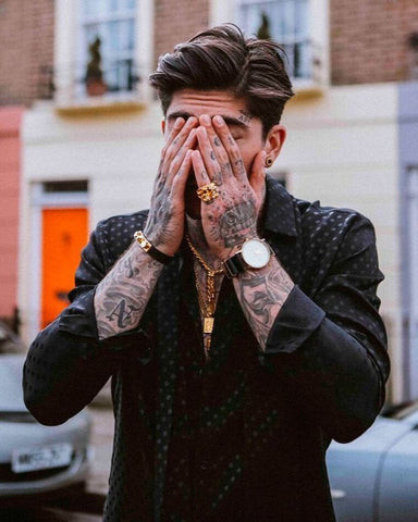 Man's hand showcasing finger tattoos, highlighting personal style and bold expression