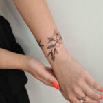 Floral bracelet tattoo on wrist, delicate and feminine design