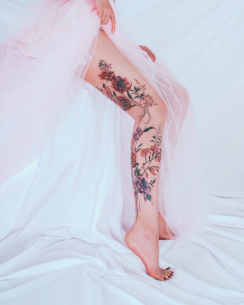 Full floral leg sleeve tattoo by Yerae, illustrating her ability to create large-scale and flowing floral cover-up tattoos.