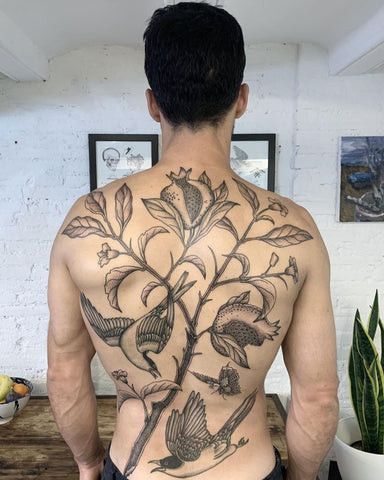 Elegant floral back tattoo for men featuring roses and vines gracefully flowing across the back, symbolizing beauty and growth.