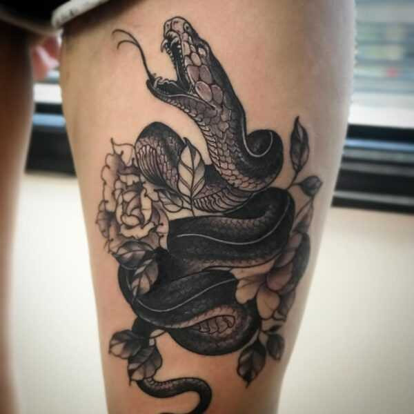 Snake tattoo with flowers enhance the beauty of nautre