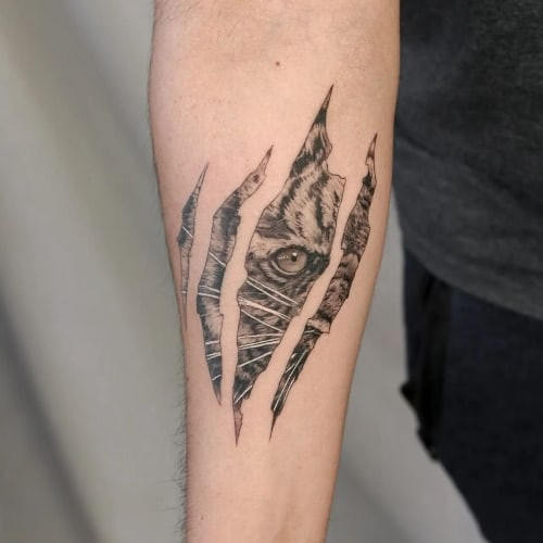 A forearm tattoo with bold shading on a man's arm, showcasing design detail