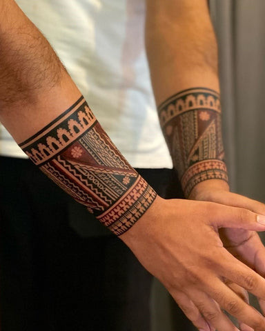 Geometric black ink forearm band tattoo, featuring sharp lines and a modern design.