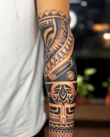 Bold black ink forearm sleeve tattoo featuring intricate patterns and shading, ideal for men seeking a large and impactful design.