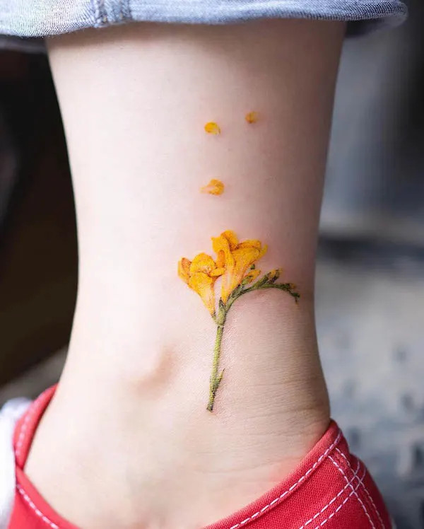 Freesia flower foot tattoo, a small ankle tattoo symbolizing friendship, hope, and joy