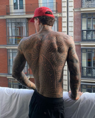 Extensive full back tattoo for men depicting a detailed mythological scene with dragons and warriors, covering the entire back from shoulders to lower back.