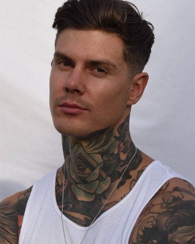 A man with a full neck tattoo showcasing a cohesive and bold design