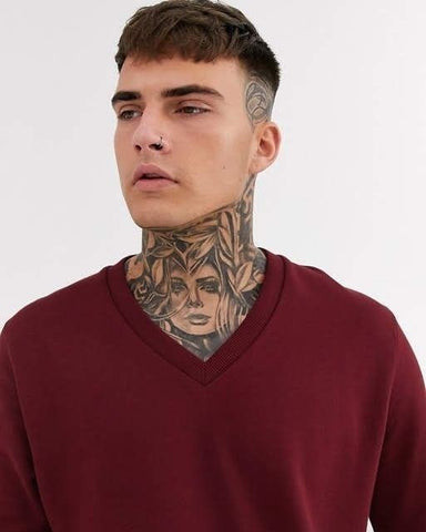 A man with an elaborate full neck tattoo featuring intricate patterns and shading, demonstrating a high-impact and artistic design.