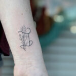 Delicate Gemini glyph tattoo on the wrist