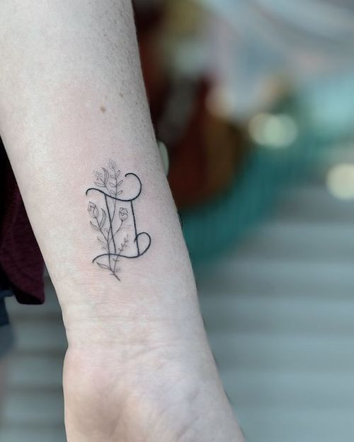 Delicate Gemini glyph tattoo on the wrist