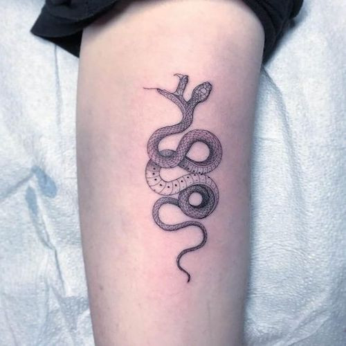 Playful snake tattoo representing Gemini's social charm