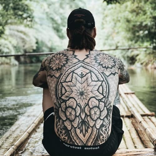 Geometric back tattoo covering a large portion of the back, featuring intricate geometric patterns suitable for a large canvas.