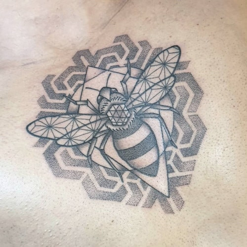 Geometric bee tattoo featuring a bee design built from geometric shapes, representing community, hard work, and nature's balance.